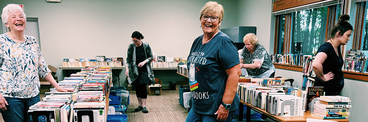 Friends of the library smiling during a book sale