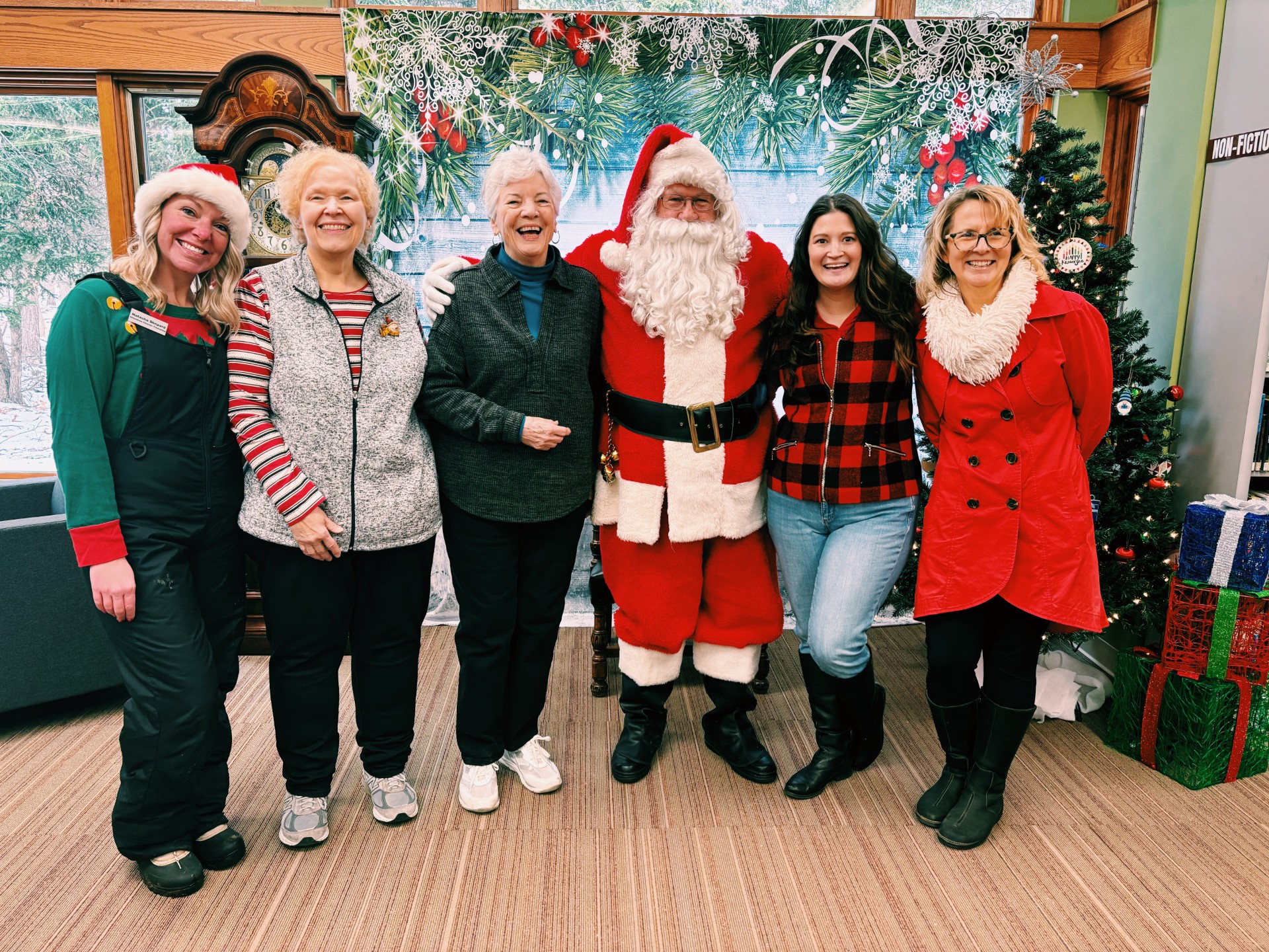 Holiday party volunteers standing with Santa.